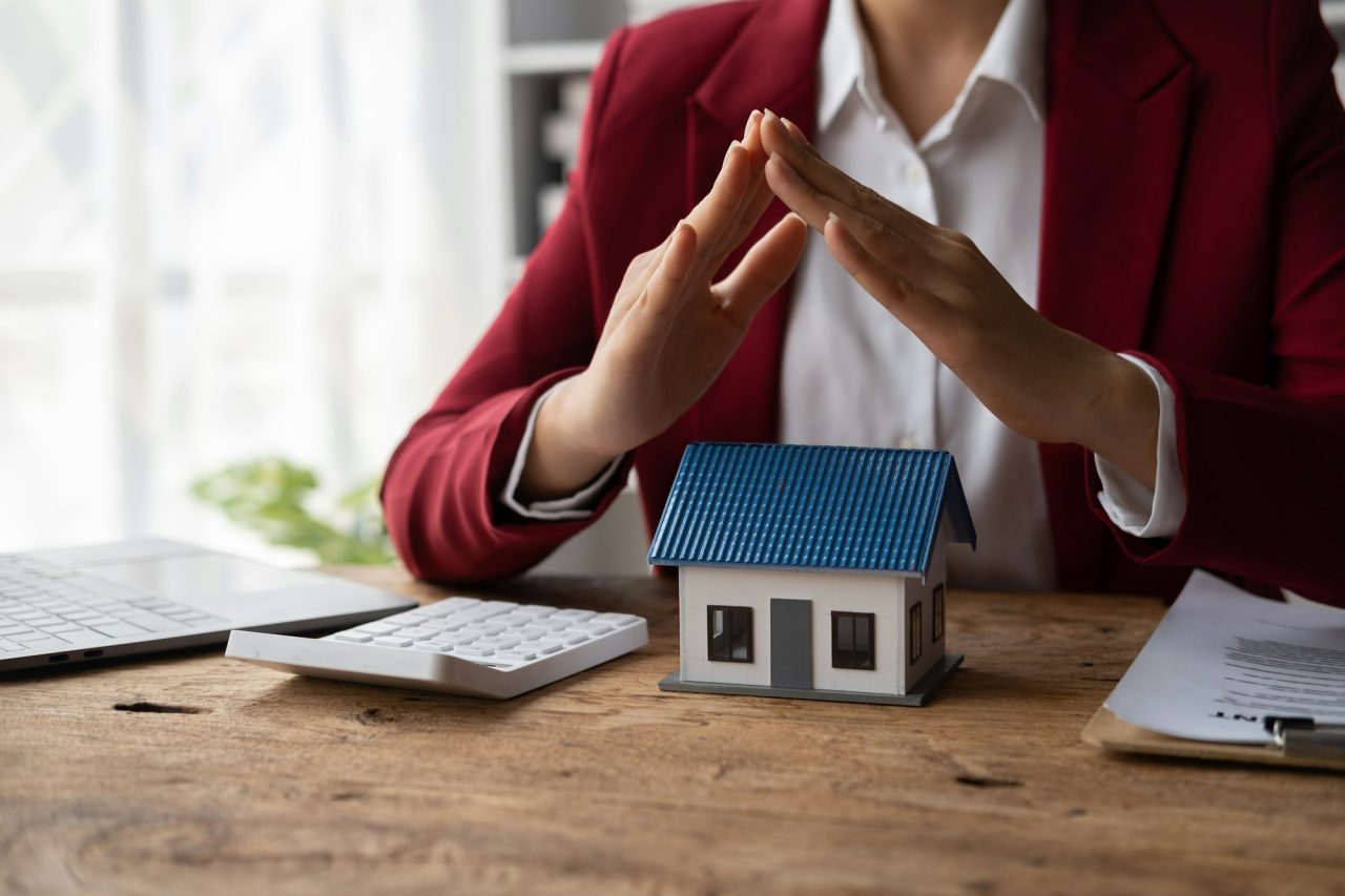 Property insurance and security concept protecting gesture of man and symbol of house .jpg